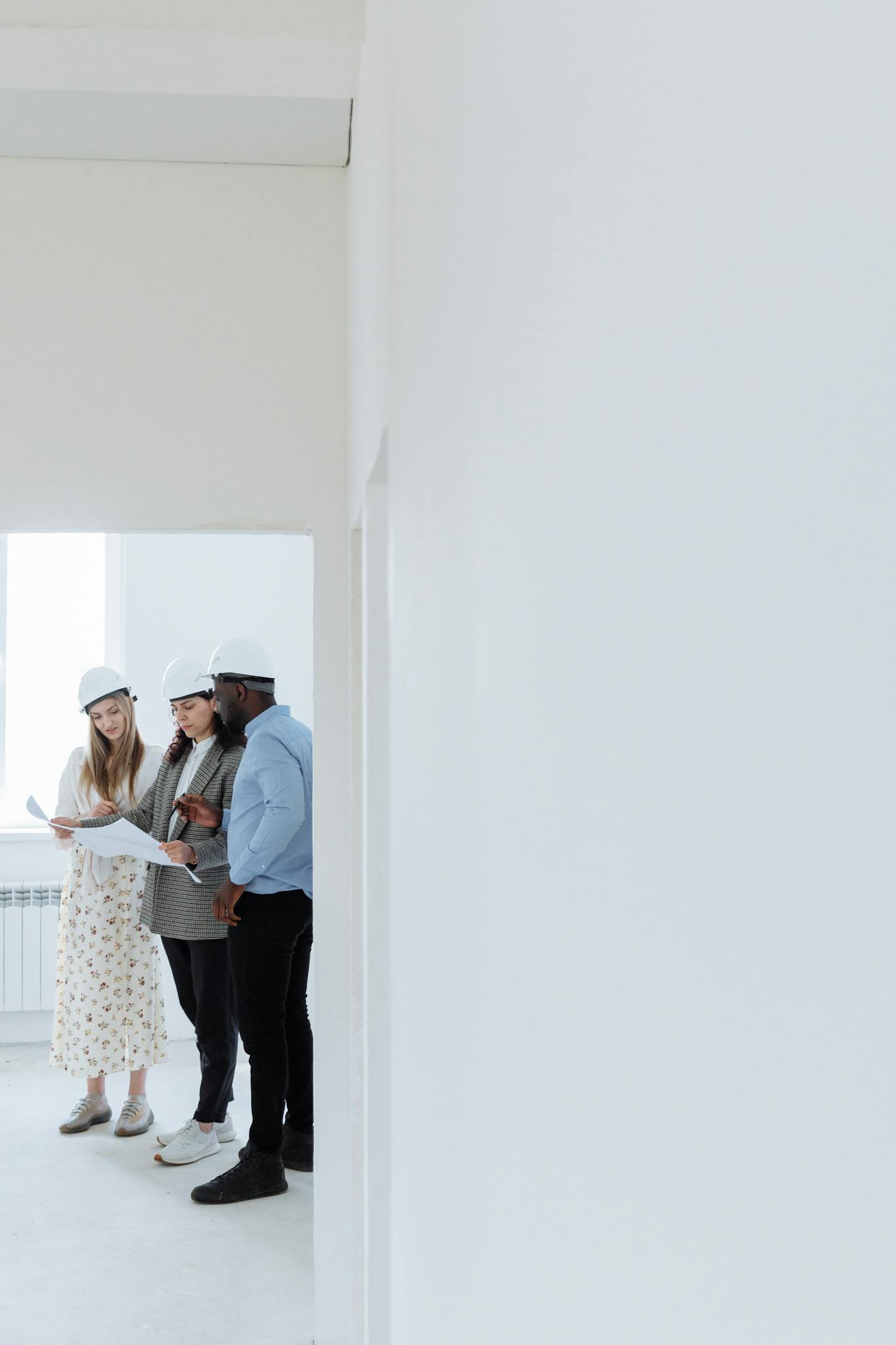 Team of architects discussing blueprints inside a newly built house.